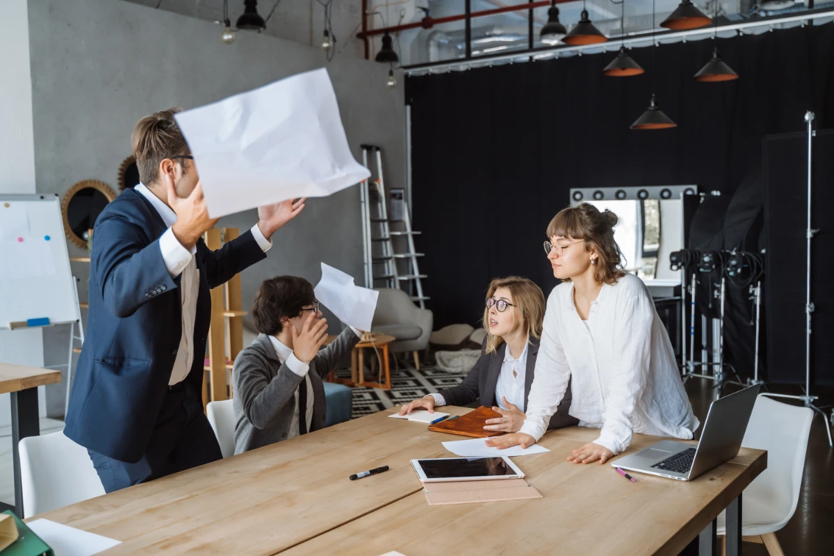 A group of business people sitting around a table in an office.