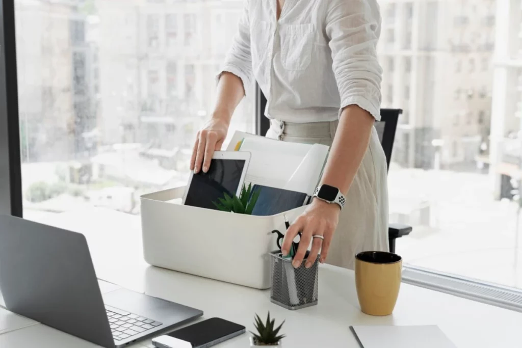 A woman is putting papers into a box in her office.