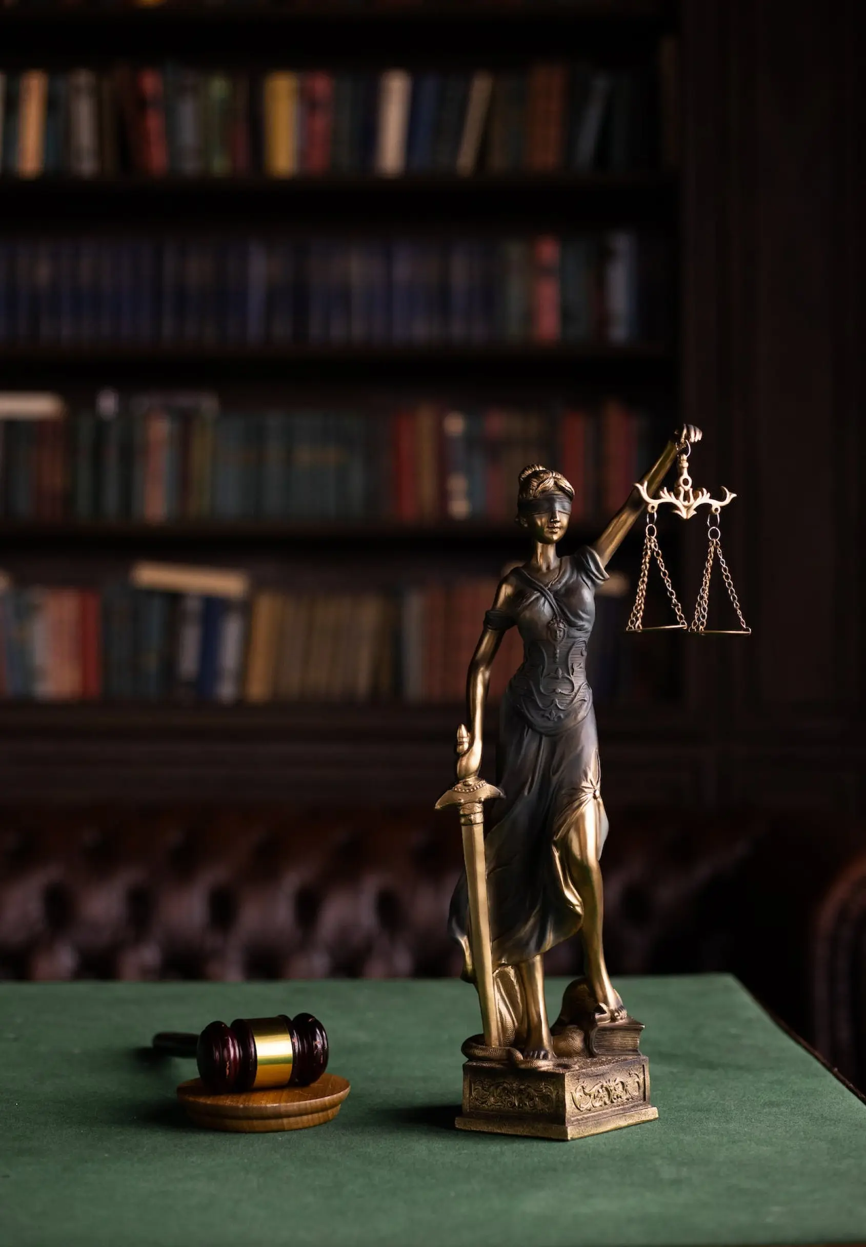 A statue of lady justice on a table in a library.