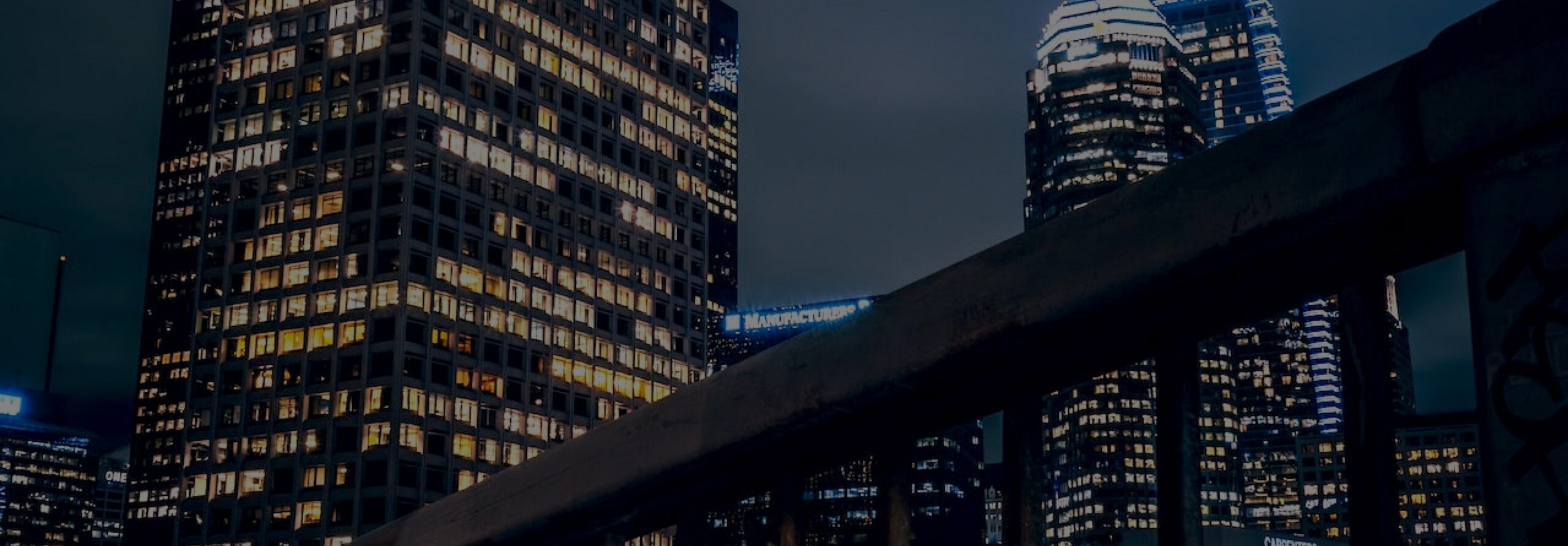 A city at night with tall buildings lit up, showcasing the mesmerizing brightness and vibrant glow of Girard Bengali's recent legal case win.