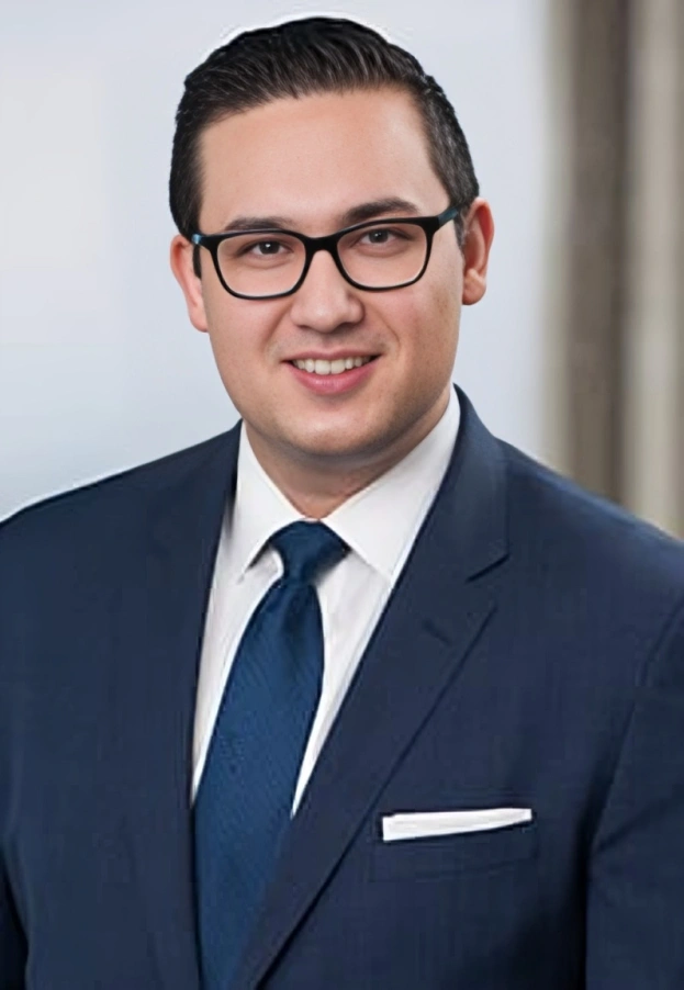 A man in a suit and tie poses for a photo.