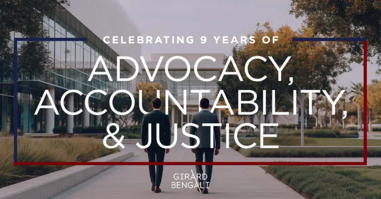 Two people in suits walk down a modern outdoor path; overlaid text reads "Celebrating 9 years of advocacy, accountability, & justice. Girard Bengali.